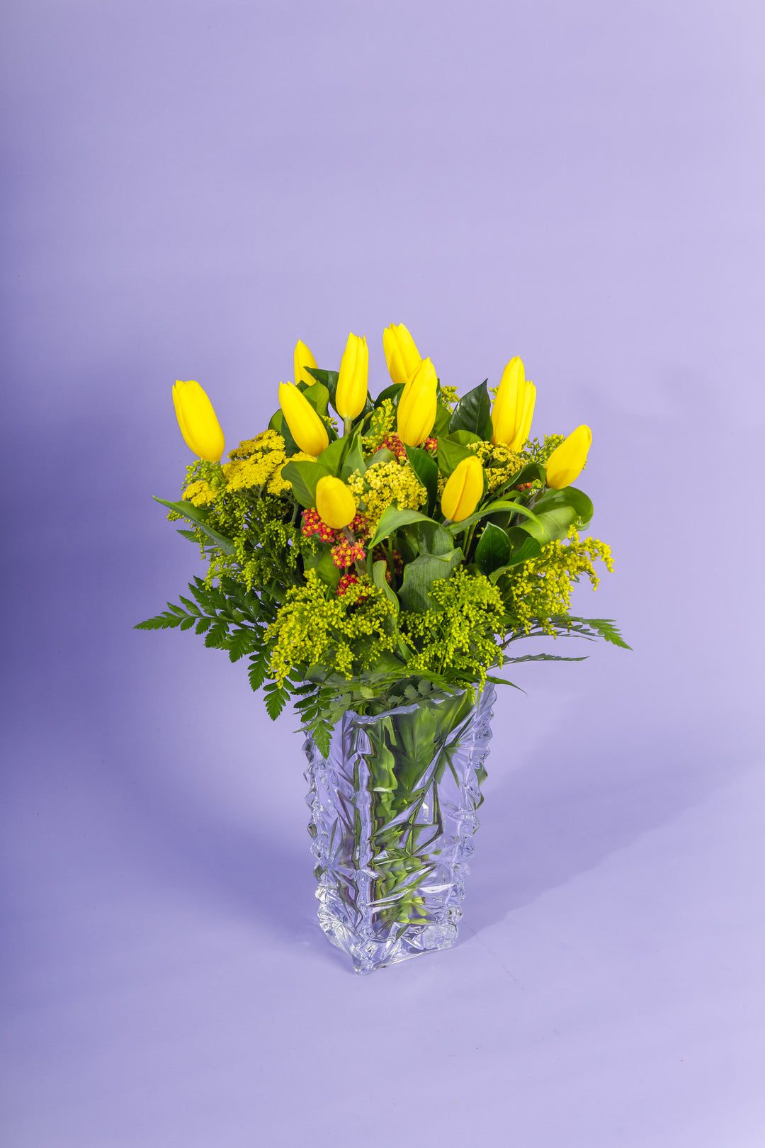 Jarron de vidrio con tulipanes amarillos
