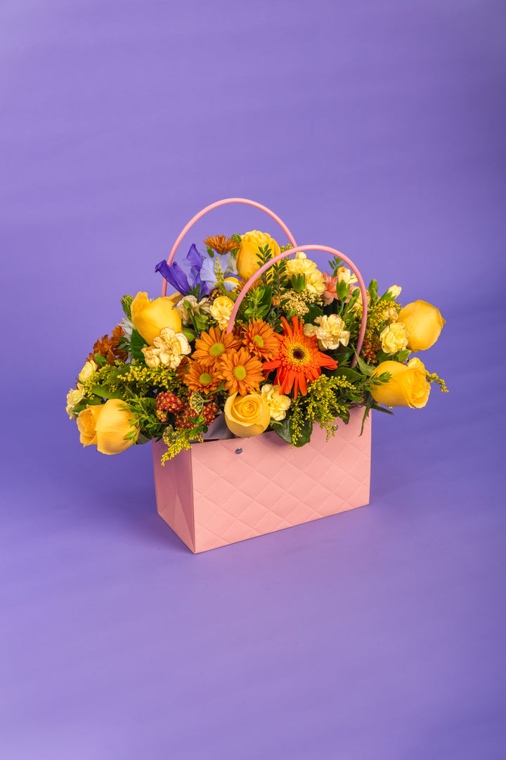 Canasta rosada con rosas amarillas