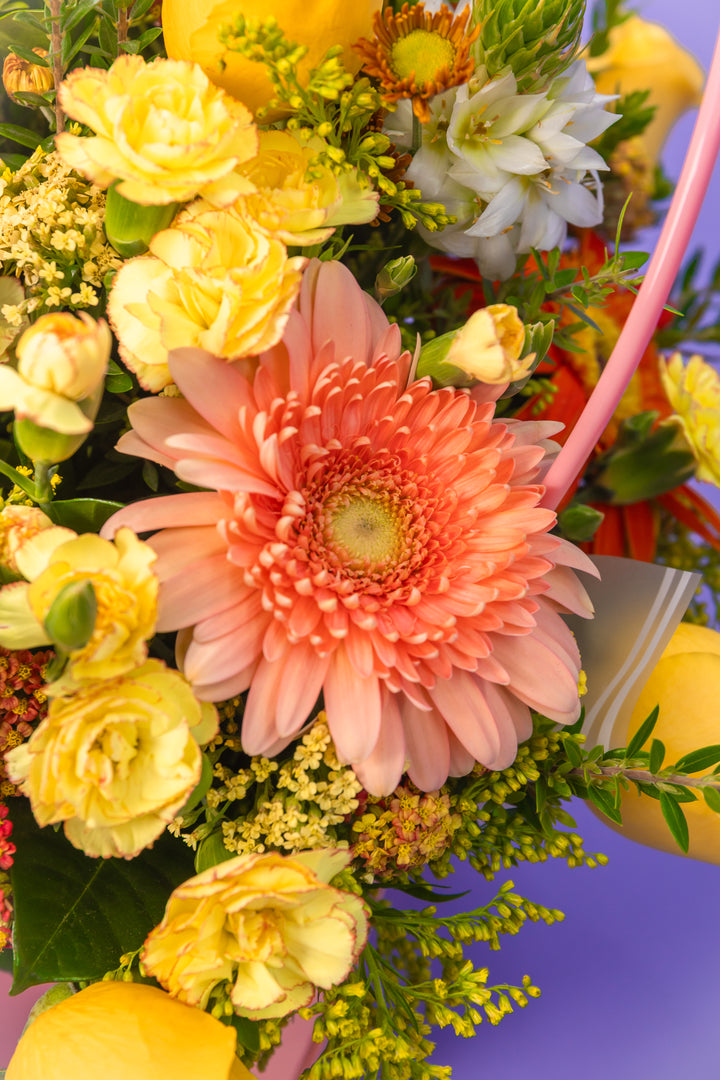 Canasta rosada con rosas amarillas