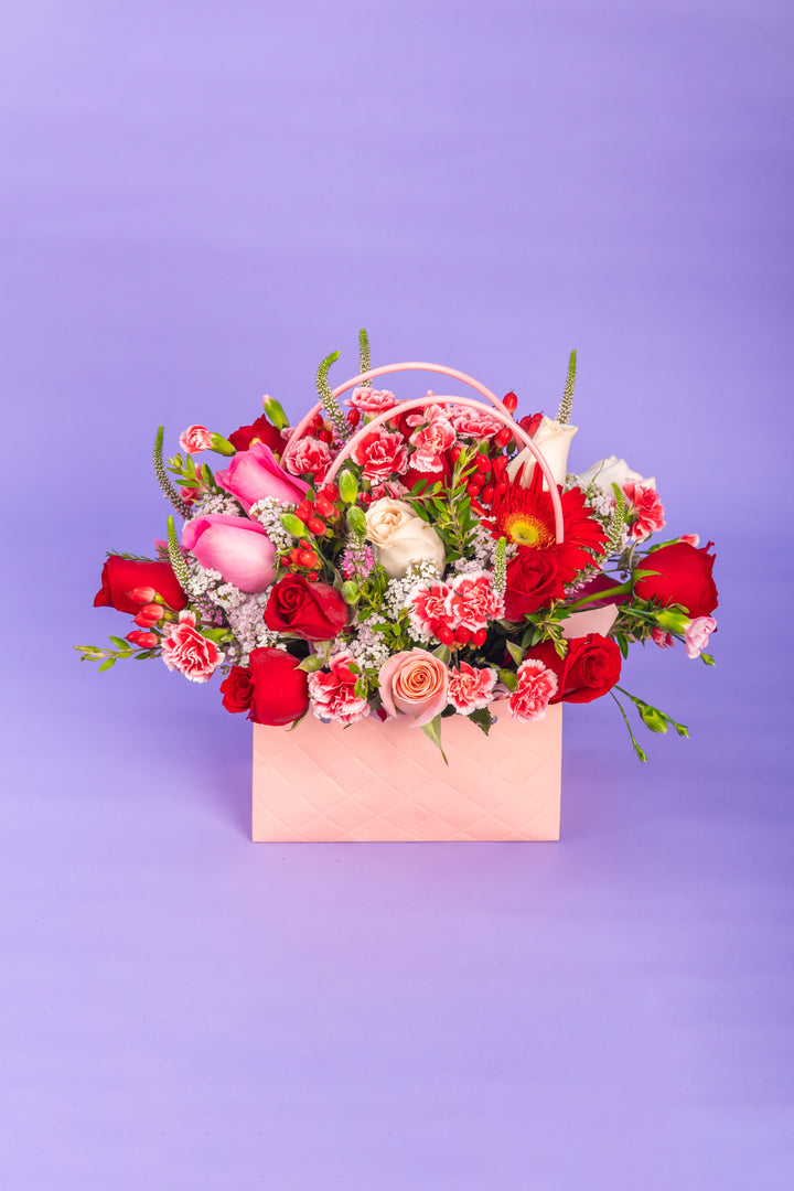 Cartera rosada con rosas rojas y rosadas