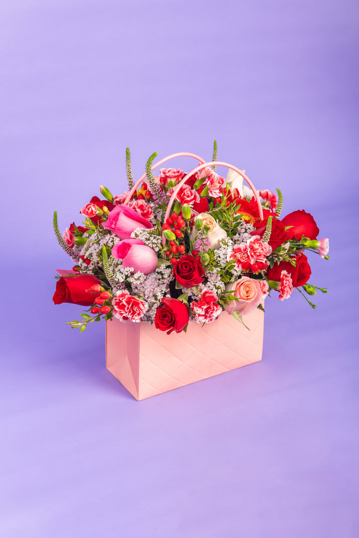 Cartera rosada con rosas rojas y rosadas