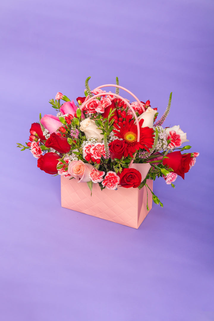 Cartera rosada con rosas rojas y rosadas
