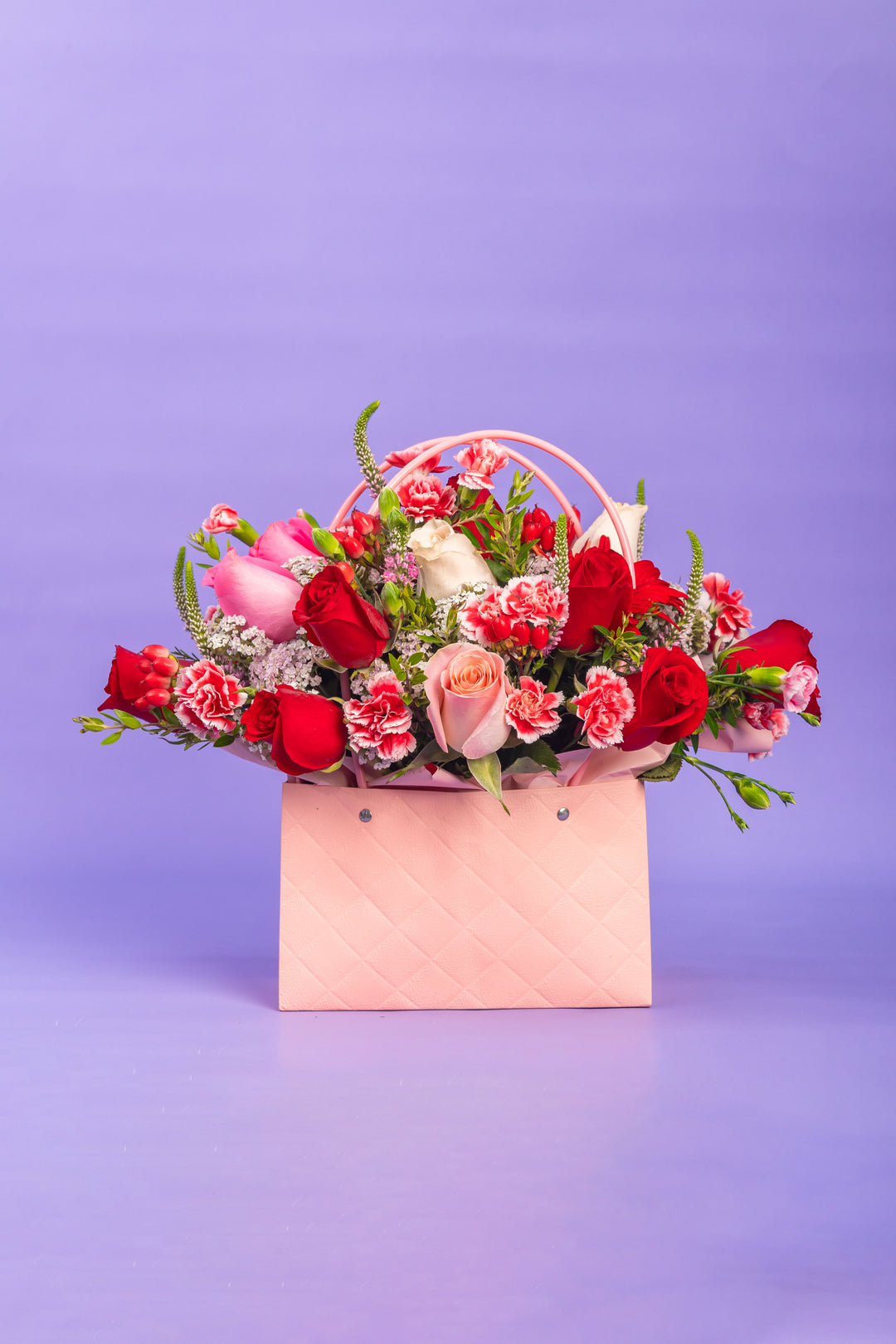 Cartera rosada con rosas rojas y rosadas